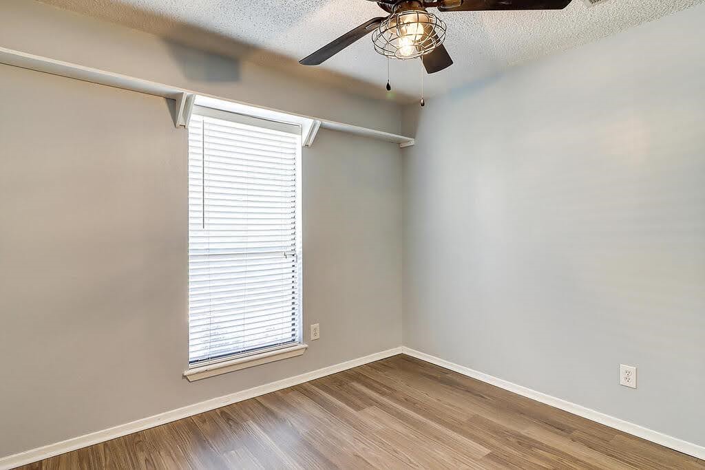 7034 Powderhorn Court Corpus Christi, TX 78413 - Photo 32 of 38 an empty room with a window and wooden floor