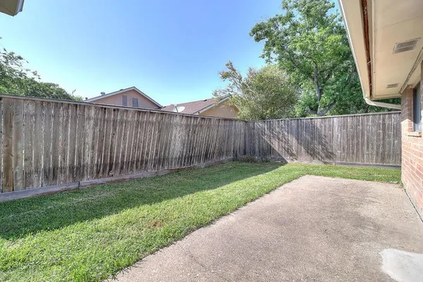 a view of backyard with wooden fence