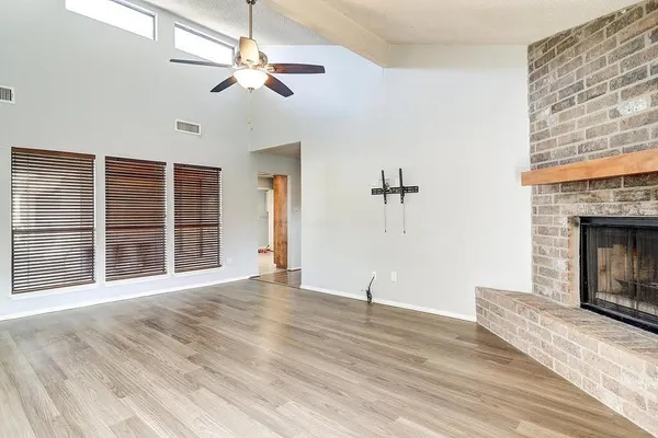 a view of an empty room with a fireplace and a window