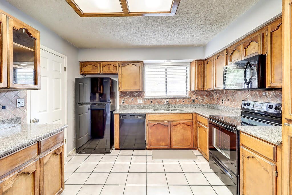 7034 Powderhorn Court Corpus Christi, TX 78413 - Photo 9 of 38 a kitchen with stainless steel appliances granite countertop a stove a sink and a microwave