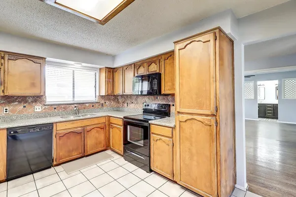 a kitchen with granite countertop cabinets stainless steel appliances a sink and a window