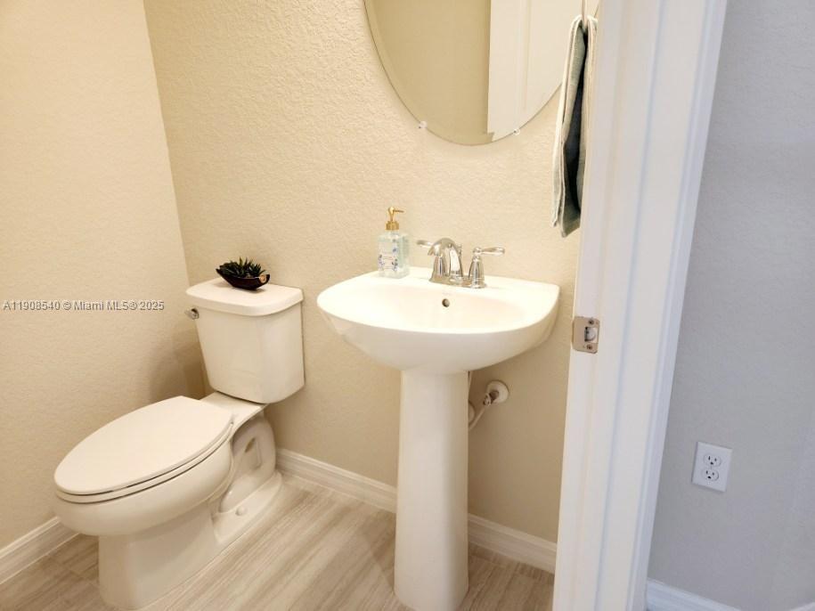 8189 Cinch Way, Unit 8189 Lake Worth, FL 33467 - Photo 11 of 11 a white toilet sitting next to a bathroom sink