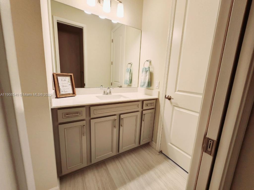 8189 Cinch Way, Unit 8189 Lake Worth, FL 33467 - Photo 6 of 11 a bathroom with a sink and a mirror