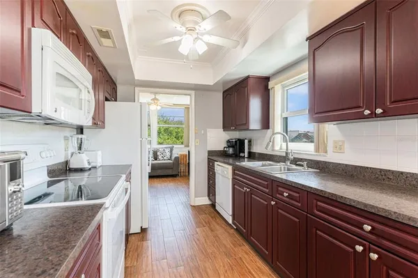 a kitchen with stainless steel appliances granite countertop wooden cabinets a stove top oven a sink and dishwasher