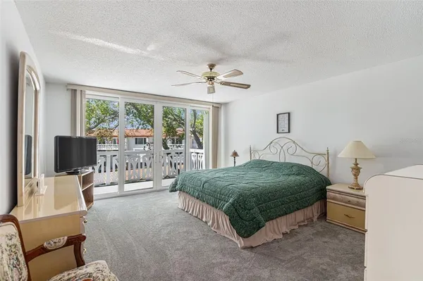 a bedroom with a bed a chandelier and a flat screen tv