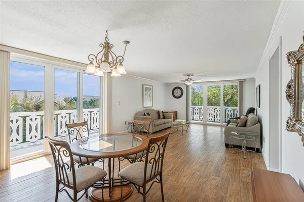 a dining room with furniture a chandelier and wooden floor