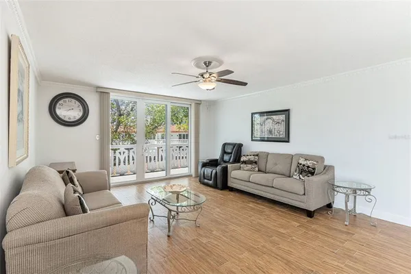 a living room with furniture a clock and a ceiling fan