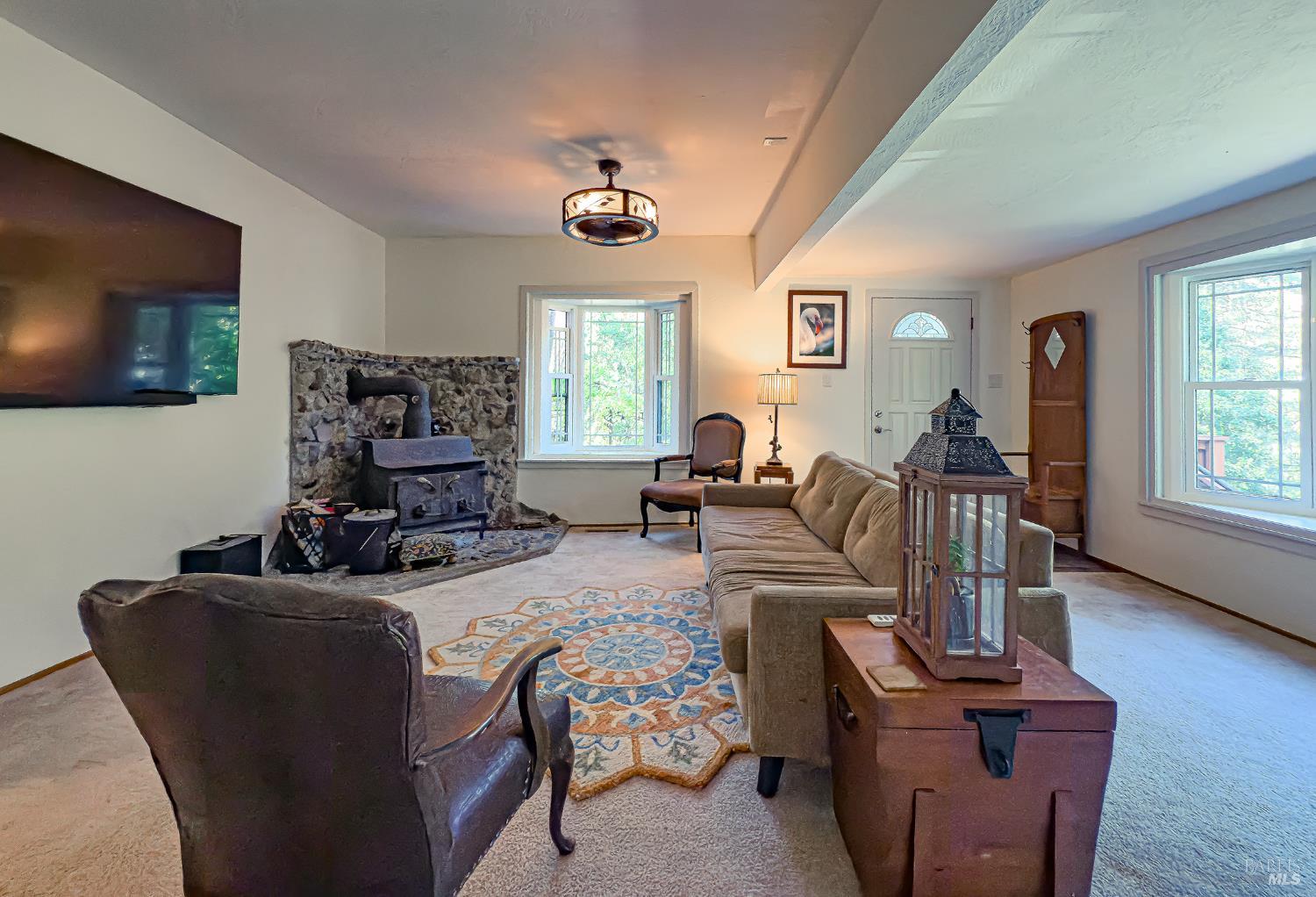 5845 Austin Creek Road Cazadero, CA 95421 - Photo 15 of 26 a living room with furniture a flat screen tv and a large window