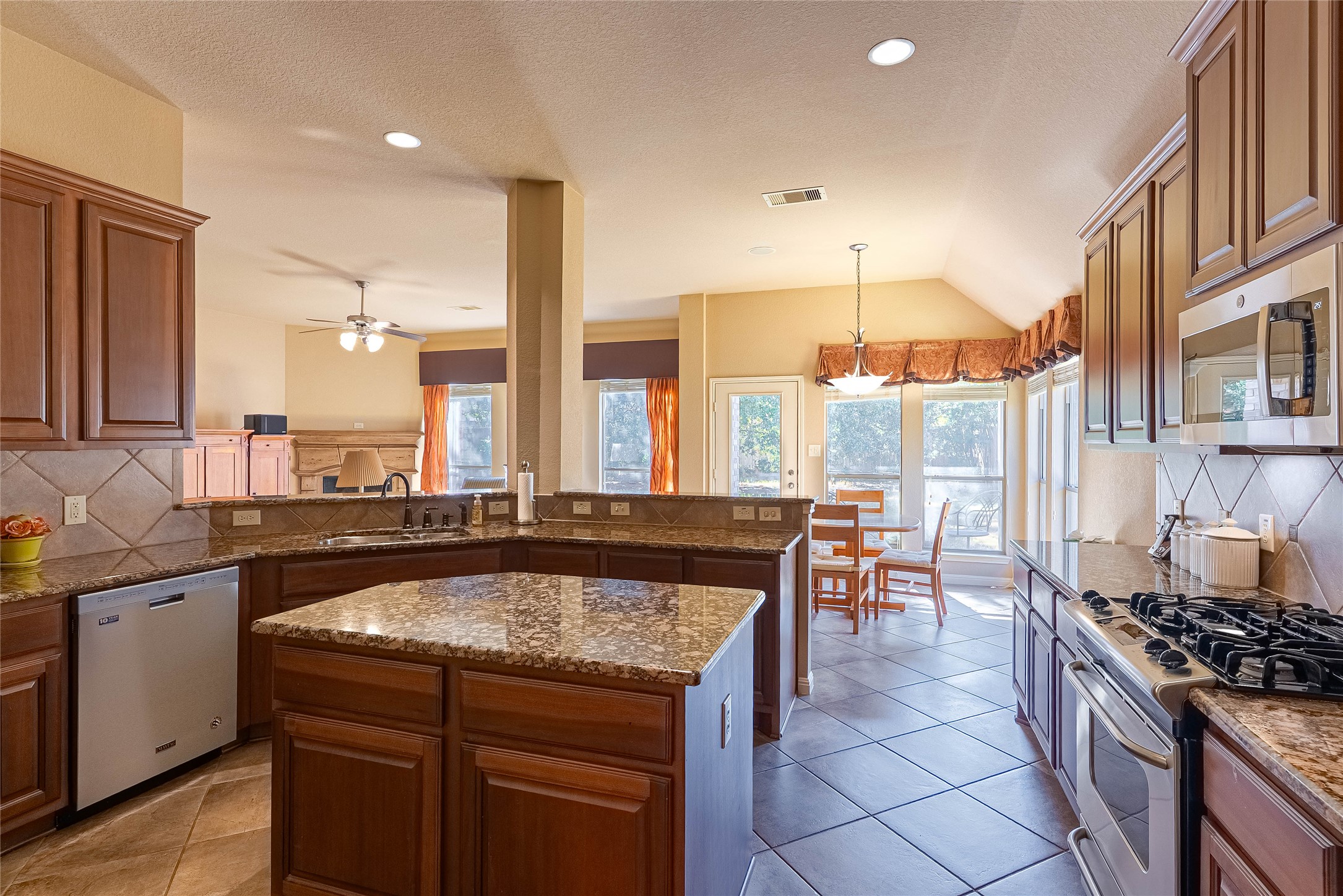 2725 Highland Trail Leander, TX 78641 - Photo 13 of 30 Gourmet kitchen with granite countertops, GE stainless appliances, and 42-inch cabinets.