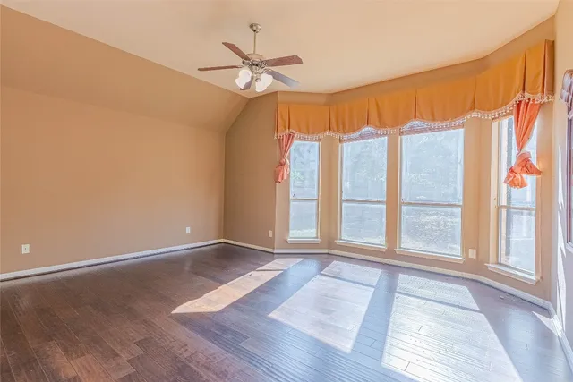 a view of an empty room with wooden floor