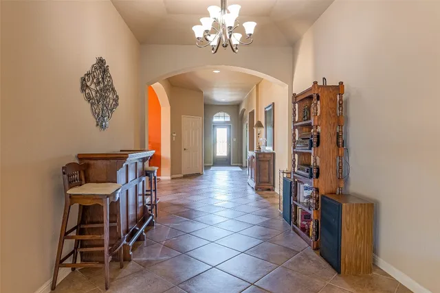 a view of a hallway with entryway a chandelier and livingroom view