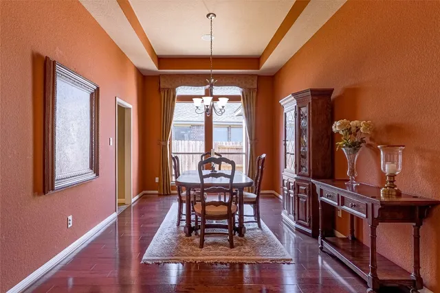 a dining room with wooden floor a chandelier