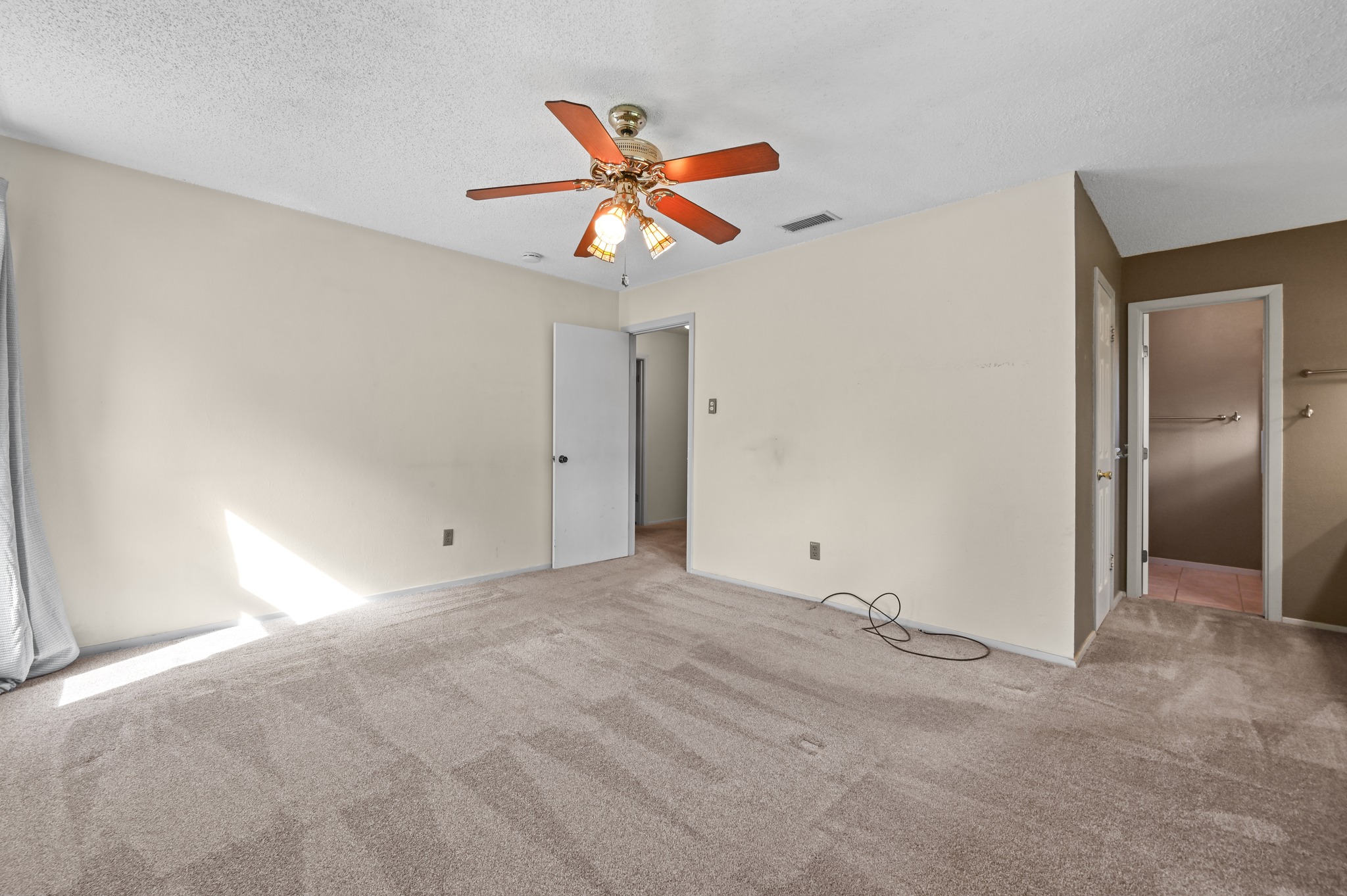 10504 Hard Rock Road Austin, TX 78750 - Photo 16 of 28 Well-lit sleeping quarters with plush carpeting and a convenient ceiling fan for comfort.