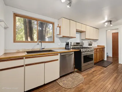 a kitchen with appliances cabinets a sink and a window