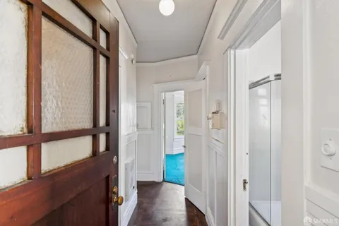 a view of a hallway with wooden floor and staircase