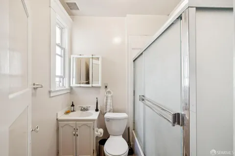 a bathroom with a toilet sink and mirror