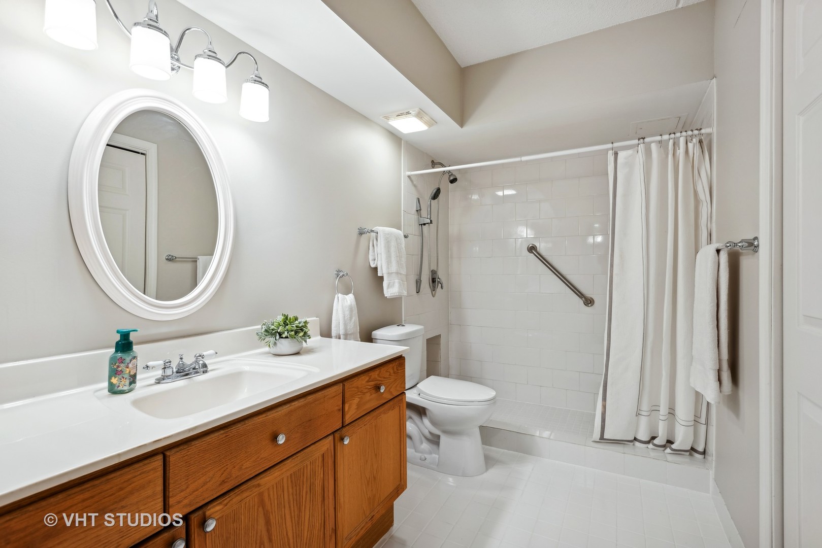 455 West Front Street, Unit 404 Wheaton, IL 60187 - Photo 11 of 16 a bathroom with a sink a toilet and a mirror