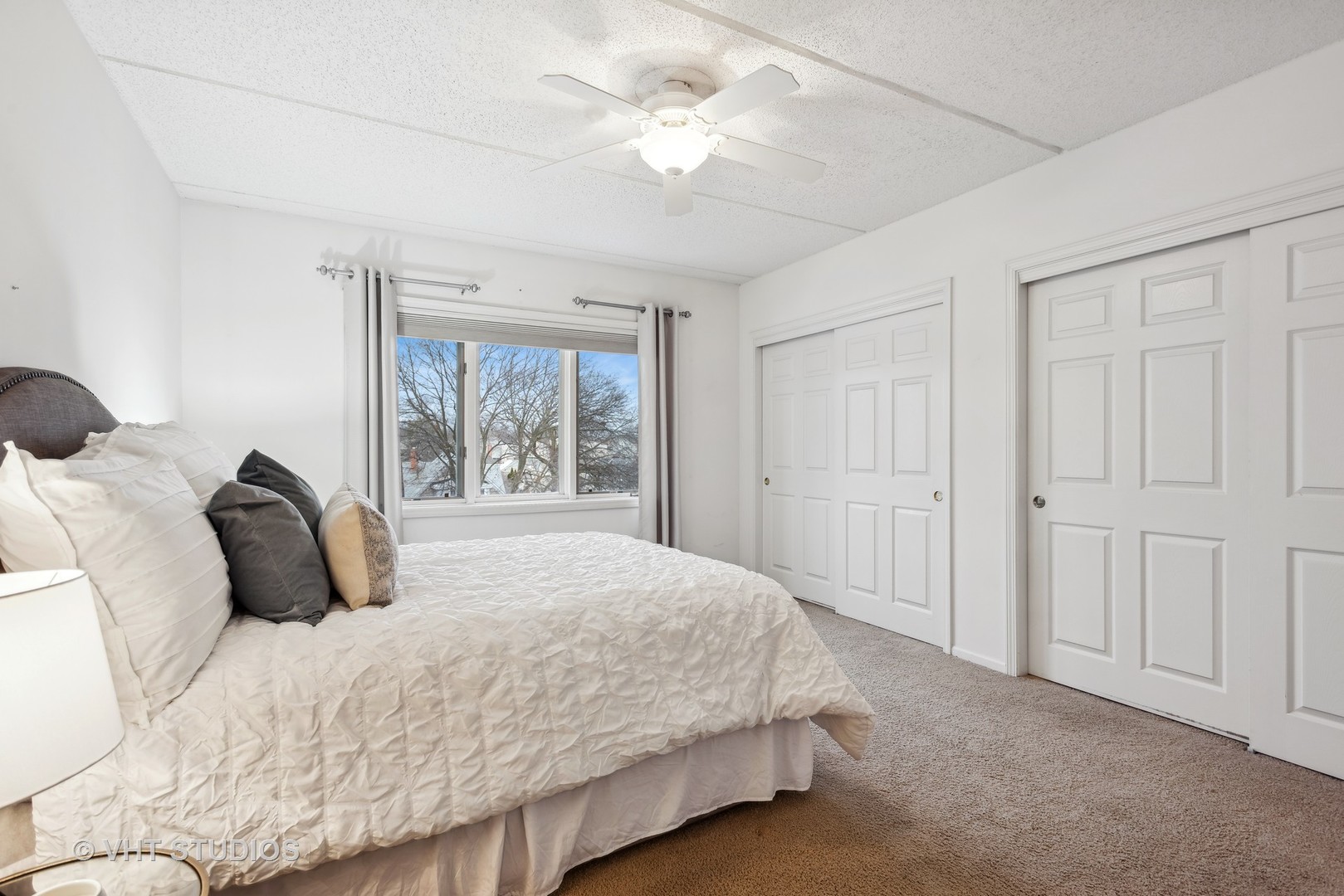 455 West Front Street, Unit 404 Wheaton, IL 60187 - Photo 10 of 16 a bedroom with a large bed and a chandelier fan