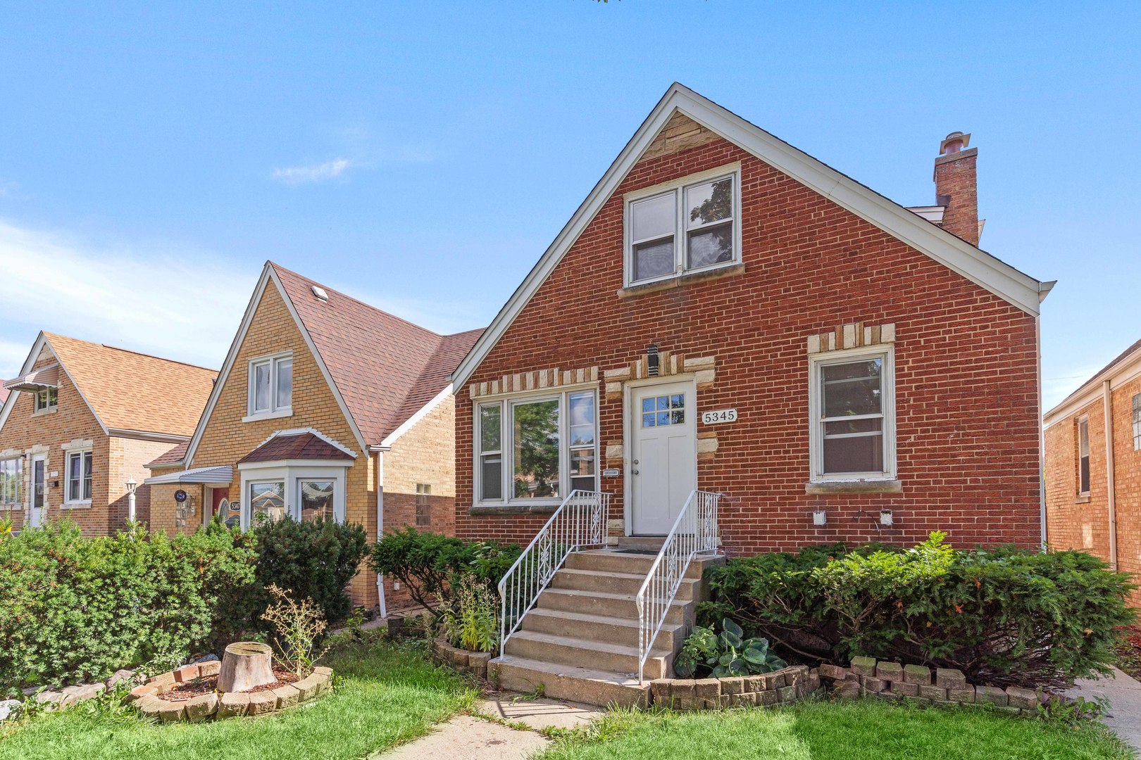a front view of a house with a yard and potted plants