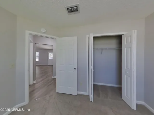 an empty room with closet and a bathroom