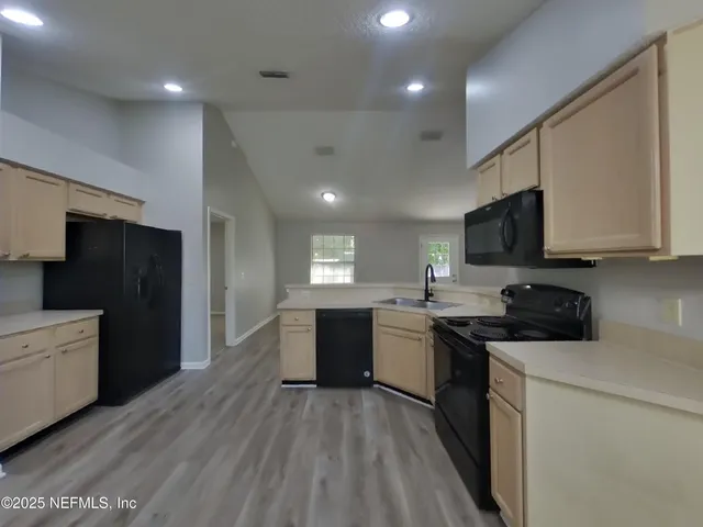 a kitchen with a sink a counter top space stainless steel appliances and cabinets