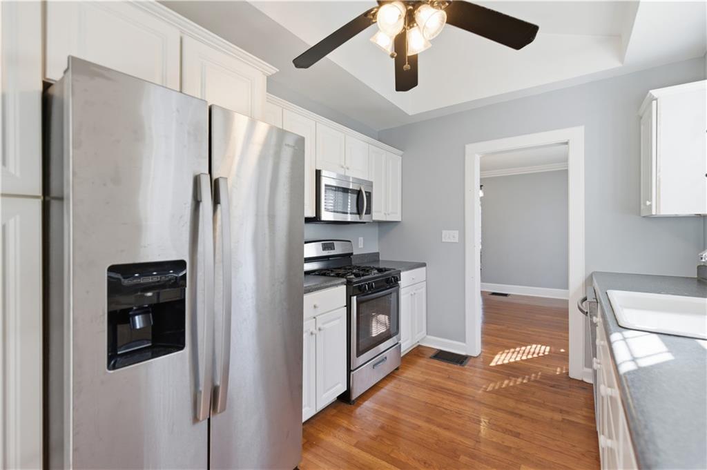 1128 Scott Boulevard Decatur, GA 30030 - Photo 9 of 45 a kitchen with stainless steel appliances a refrigerator a stove a microwave and white cabinets