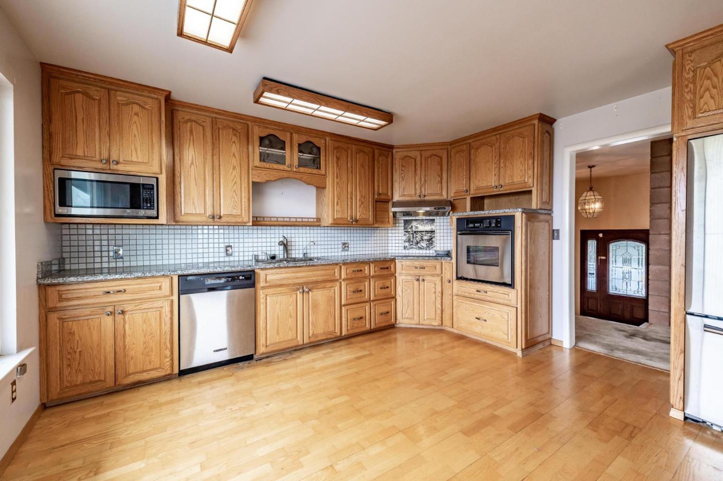 380 Hillside Road San Juan Bautista, CA 95045 - Photo 12 of 60 a large kitchen with stainless steel appliances granite countertop a stove a sink and a microwave