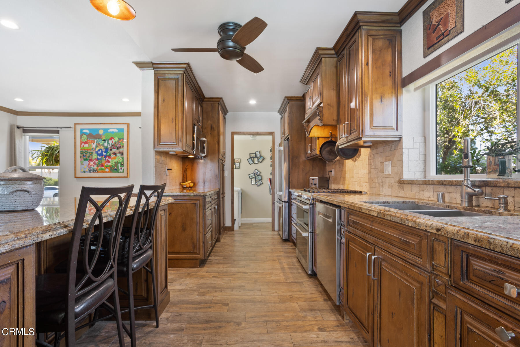 9400 Crystal View Drive Tujunga, CA 91042 - Photo 25 of 67 a kitchen with stainless steel appliances granite countertop a refrigerator a sink dishwasher a dining table and chairs with wooden floor