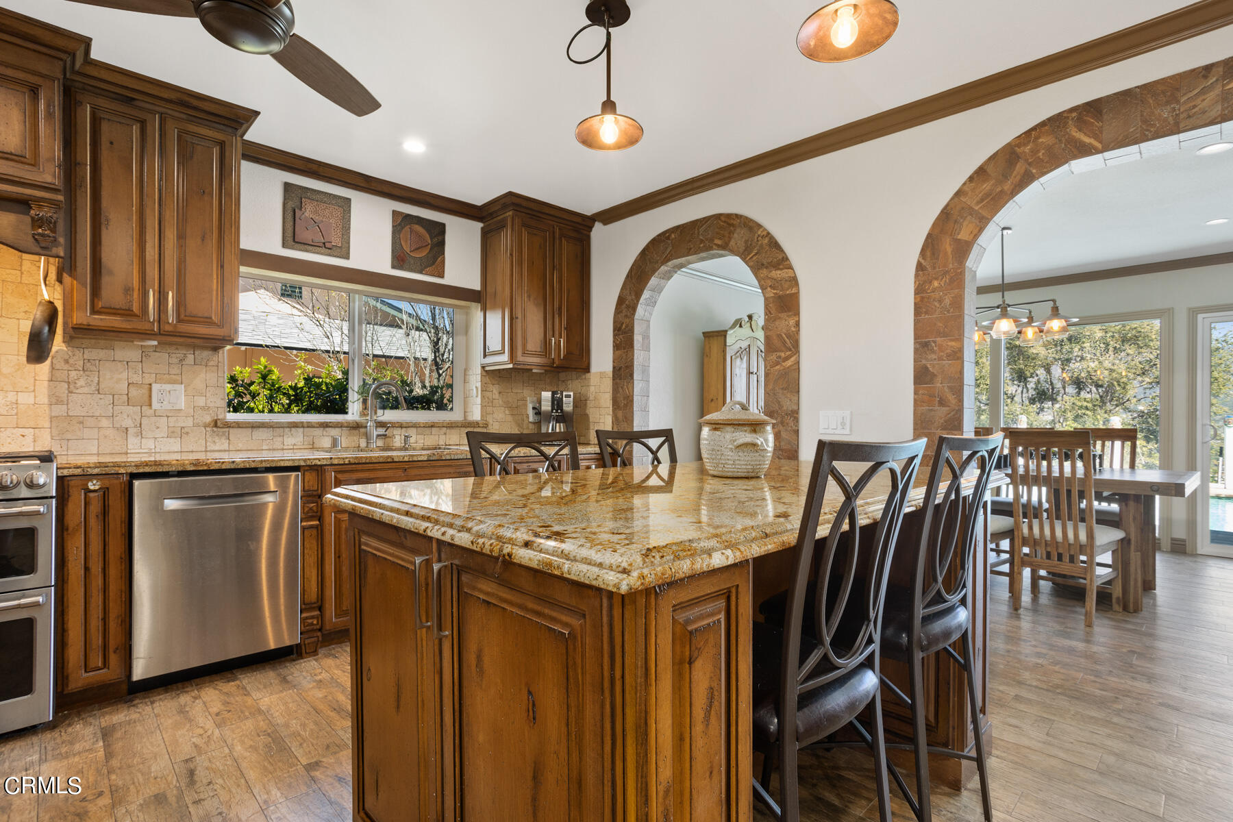 9400 Crystal View Drive Tujunga, CA 91042 - Photo 33 of 67 a kitchen with stainless steel appliances granite countertop a kitchen island a stove a table and chairs with wooden floor