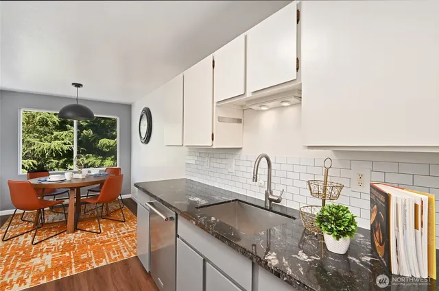 a kitchen with stainless steel appliances granite countertop a sink a stove and a wooden cabinets