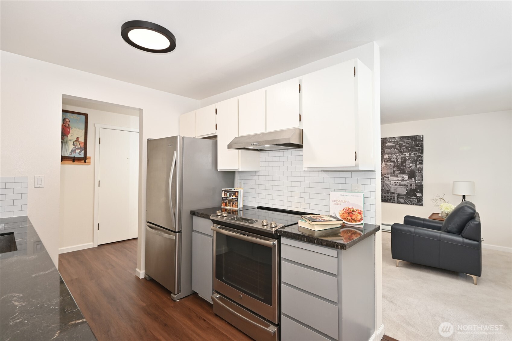7021 Sand Point Way Northeast, Unit B319 Seattle, WA 98115 - Photo 7 of 29 a kitchen with stainless steel appliances a refrigerator a sink a stove and white cabinets