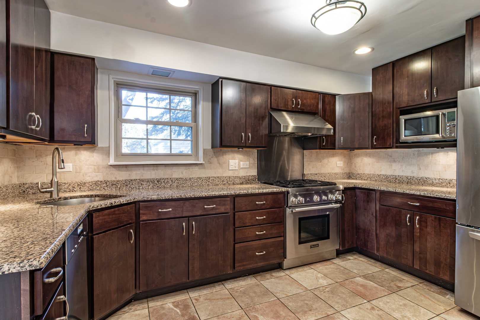 640 Sanders Court Gurnee, IL 60031 - Photo 12 of 38 a kitchen with stainless steel appliances granite countertop wooden cabinets stove top oven and sink