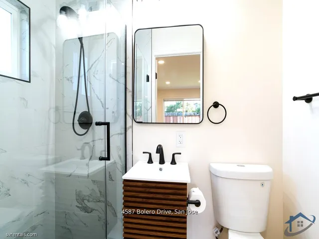 a bathroom with a sink a toilet and a mirror