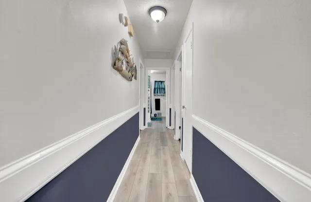 a view of a hallway with wooden floor