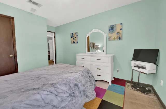 a bedroom with a bed and a dresser in it