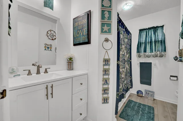 a en suite bathroom with a sink vanity granite and a mirror