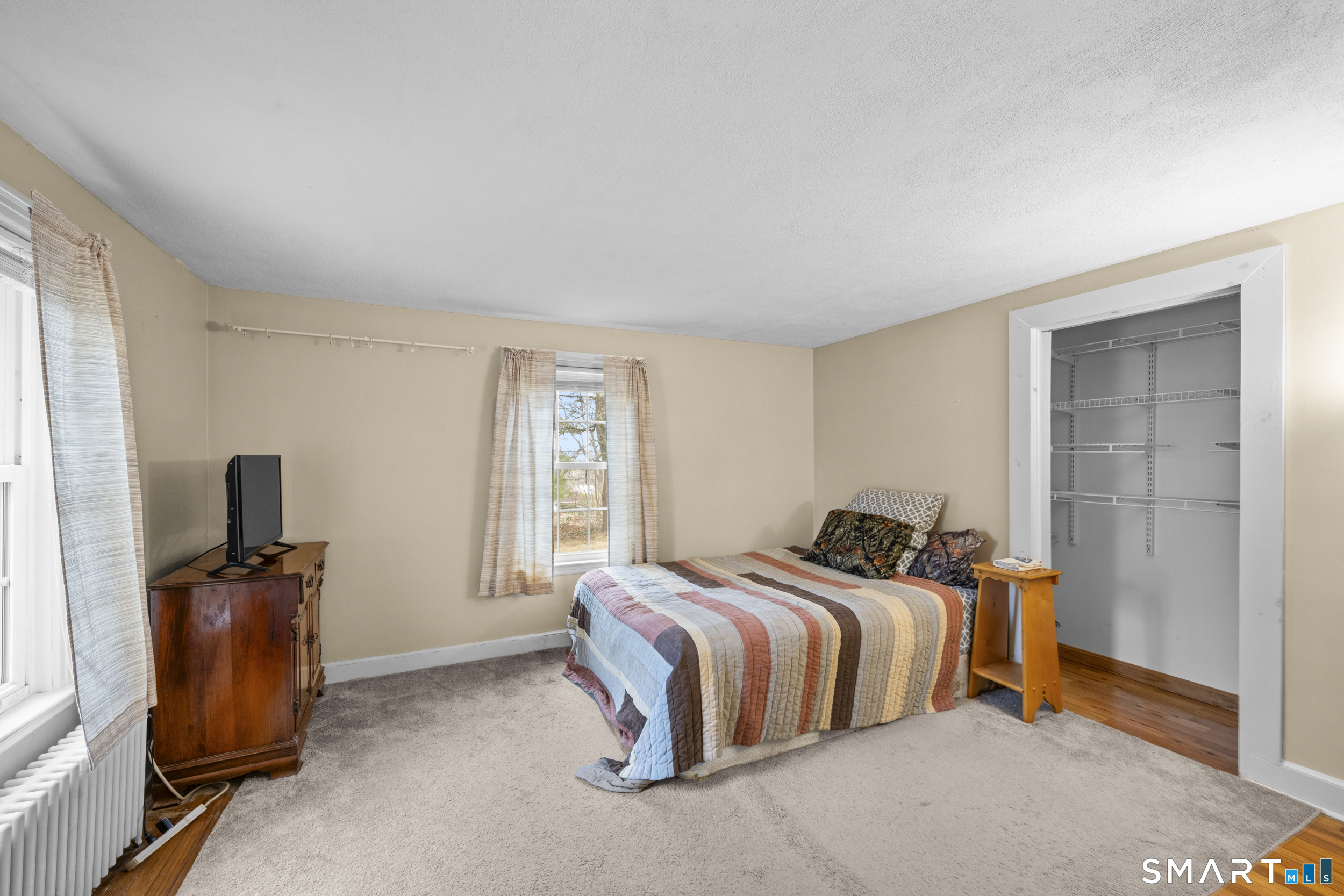 26 Field Street Stonington, CT 06379 - Photo 14 of 20 a bedroom with a bed and a flat screen tv