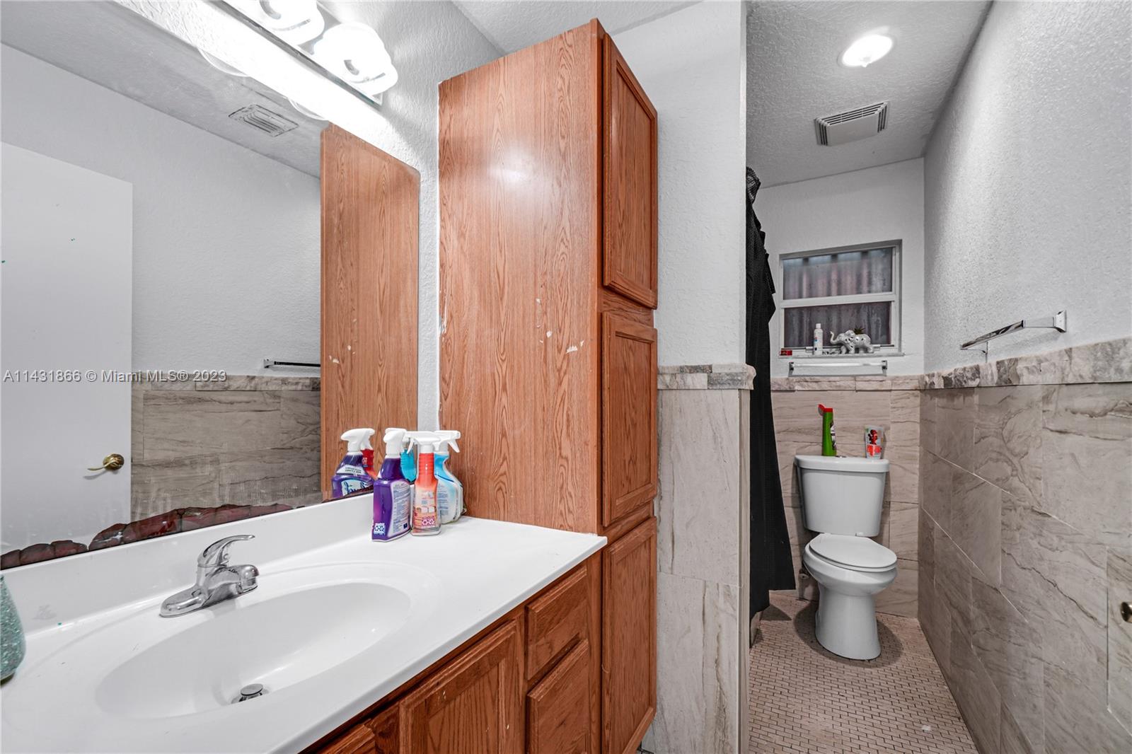 24313 Southwest 130th Avenue Homestead, FL 33032 - Photo 14 of 23 a bathroom with a sink vanity mirror and toilet