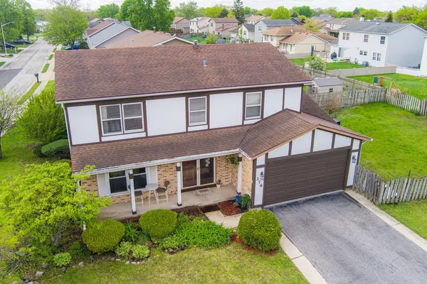 a aerial view of a house next to a yard