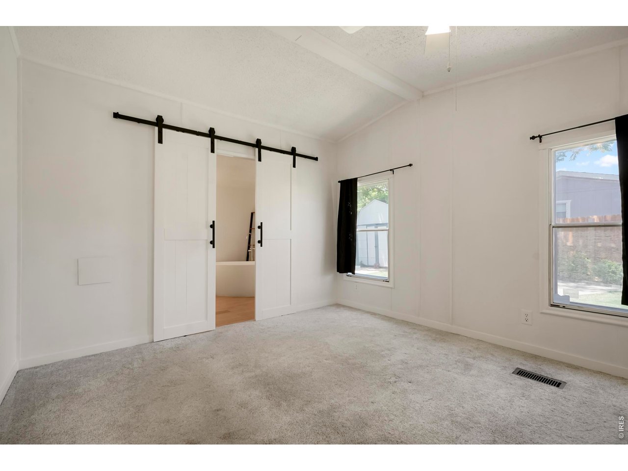 8451 Madison Way Denver, CO 80229 - Photo 10 of 27 Primary Bedroom with Barn Doors Leading into Primary Oasis