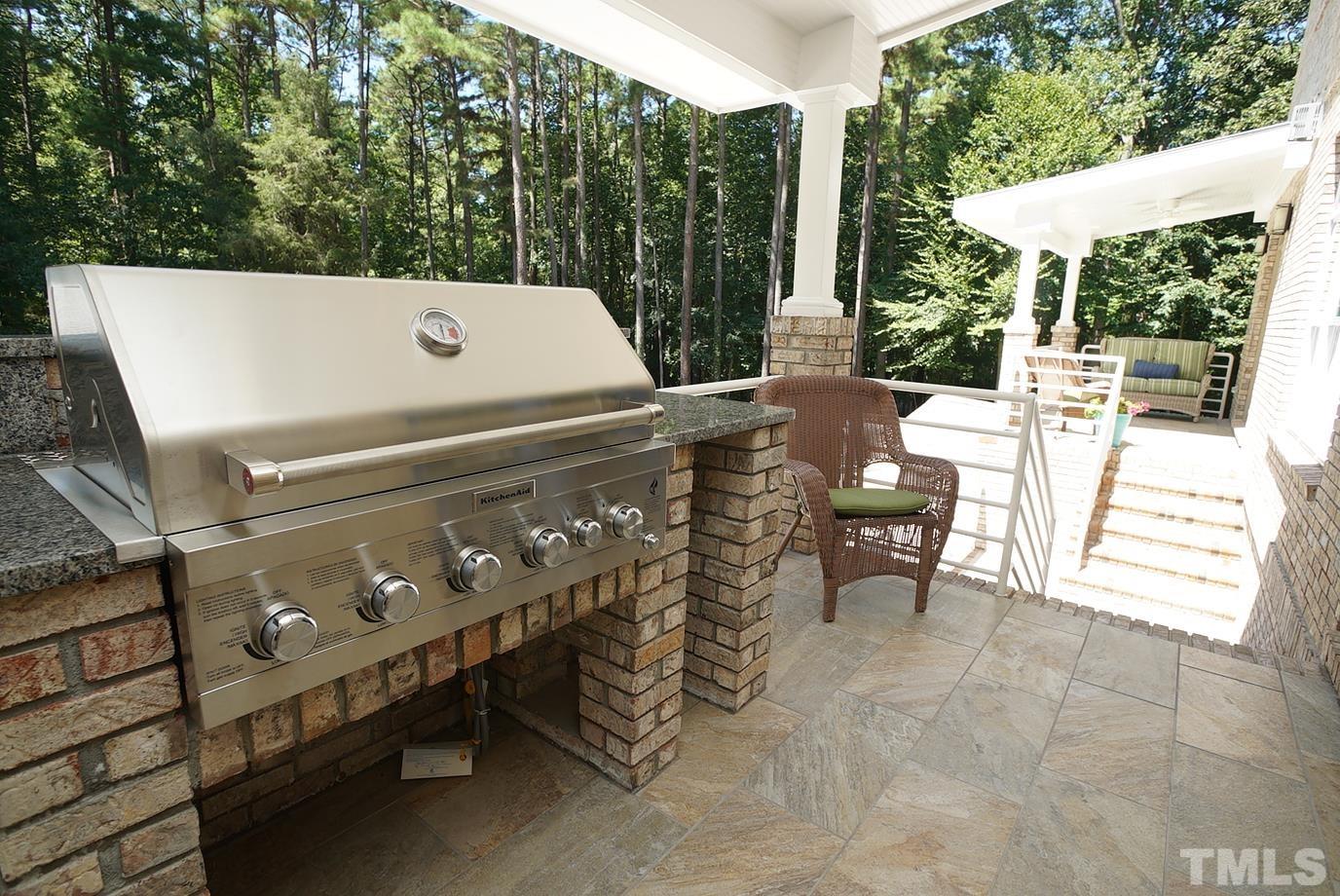 6007 Graystone Drive Chapel Hill, NC 27514 - Photo 21 of 30 Covered balcony off kitchen/living area has a new gas grill and tile flooring.