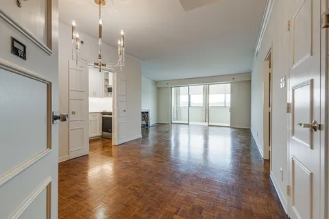 a view of a hallway with wooden floor and windows