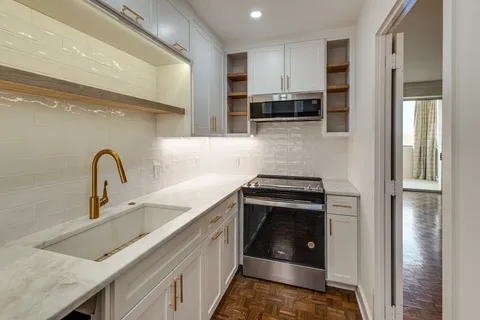 a kitchen with stainless steel appliances granite countertop a sink a stove and a refrigerator