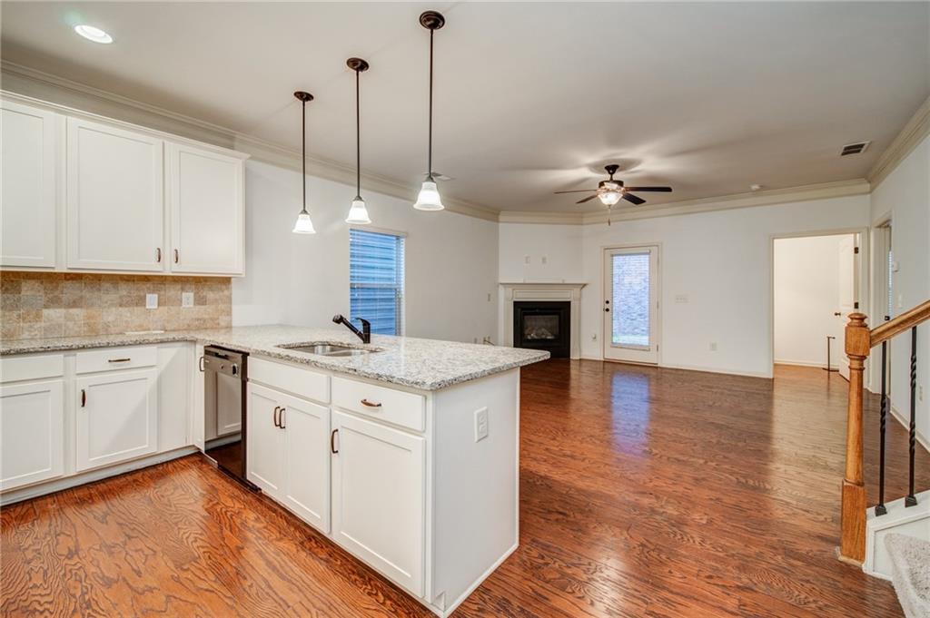 a open kitchen with stainless steel appliances granite countertop a sink a stove and a wooden floors