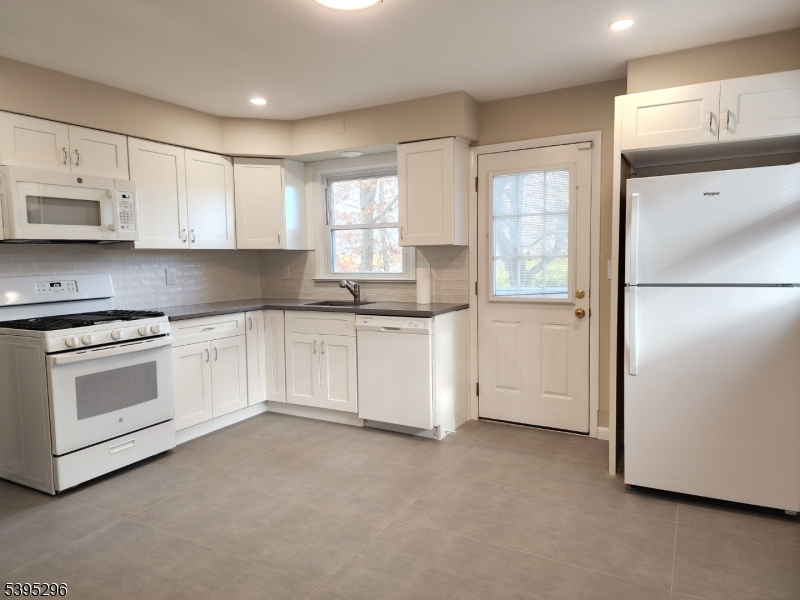 84 Reservoir Avenue Butler, NJ 07405 - Photo 6 of 20 a kitchen with white cabinets and white appliances