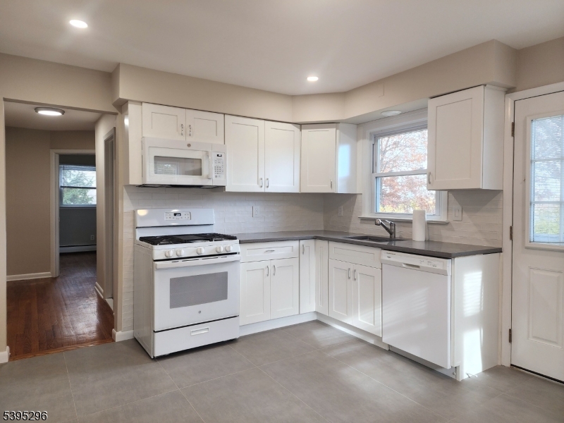 84 Reservoir Avenue Butler, NJ 07405 - Photo 7 of 20 a kitchen with stainless steel appliances white cabinets and a sink