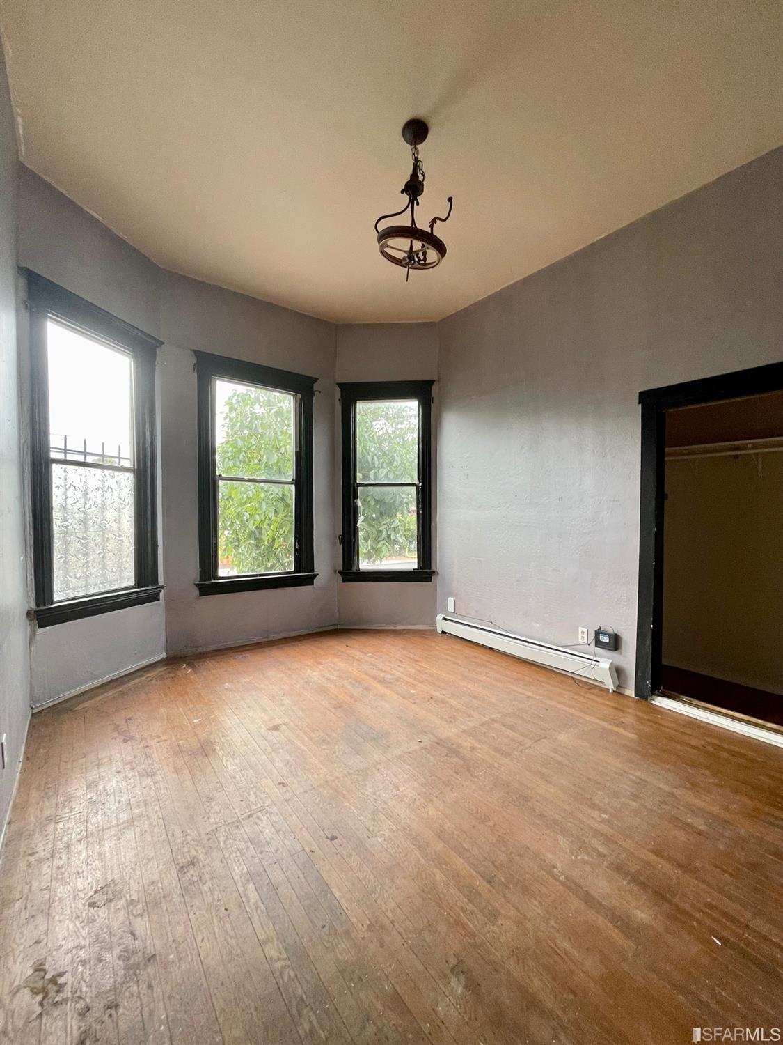 1022 24th Street Oakland, CA 94607 - Photo 3 of 9 an empty room with windows and chandelier fan