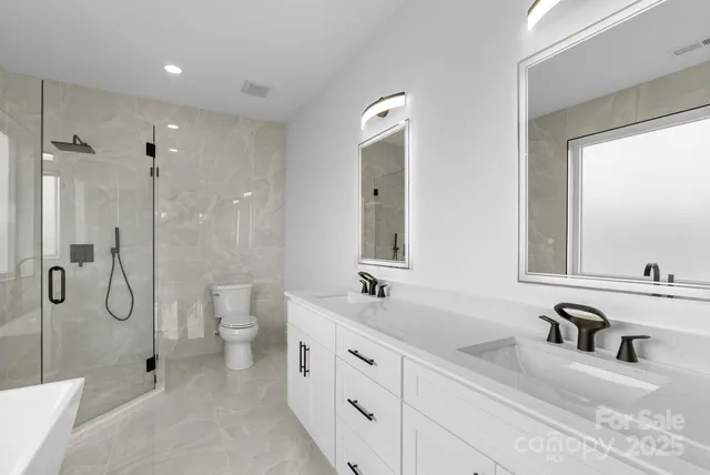 a bathroom with a tub a toilet and a shower