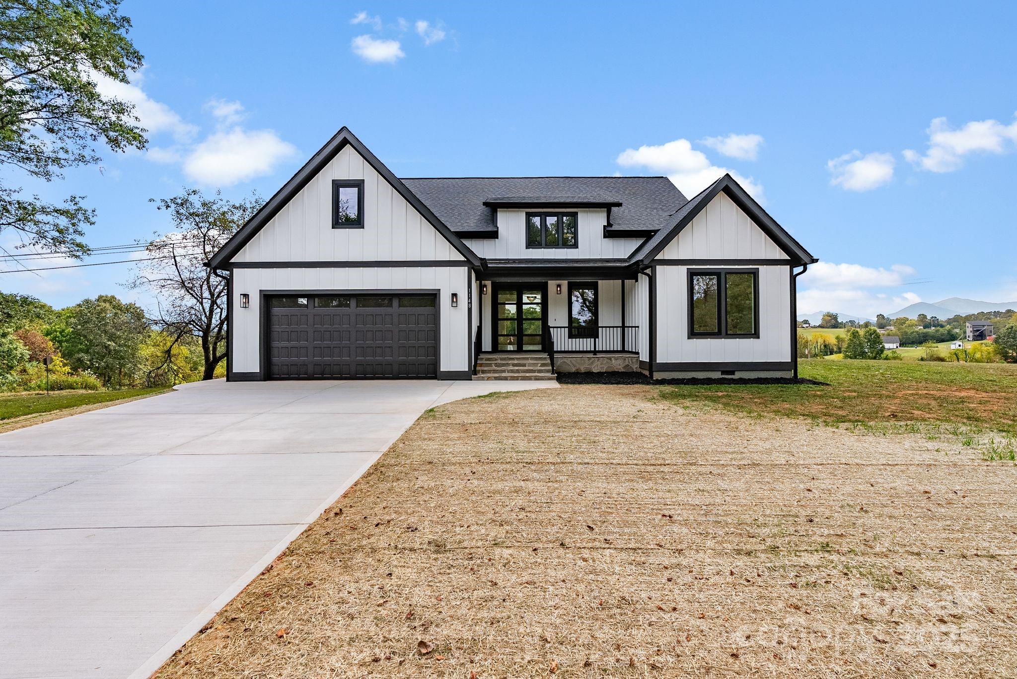 1148 Alexander Road Leicester, NC 28748 - Photo 41 of 47 a front view of a house with a yard and garage