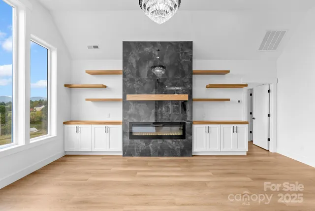 a large white kitchen with stainless steel appliances kitchen island granite countertop a refrigerator and cabinets